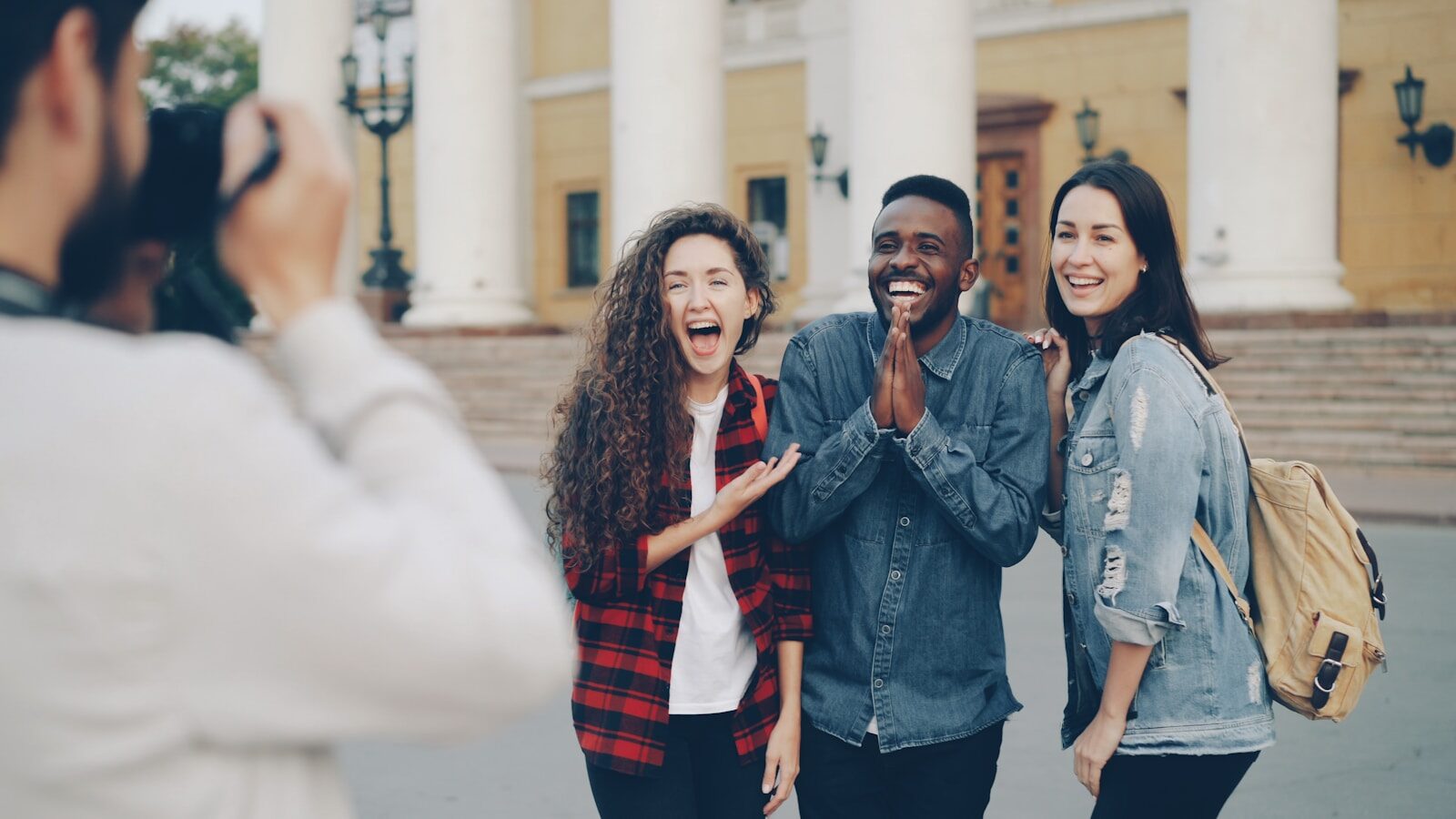 People happily pose for a photograph outside.